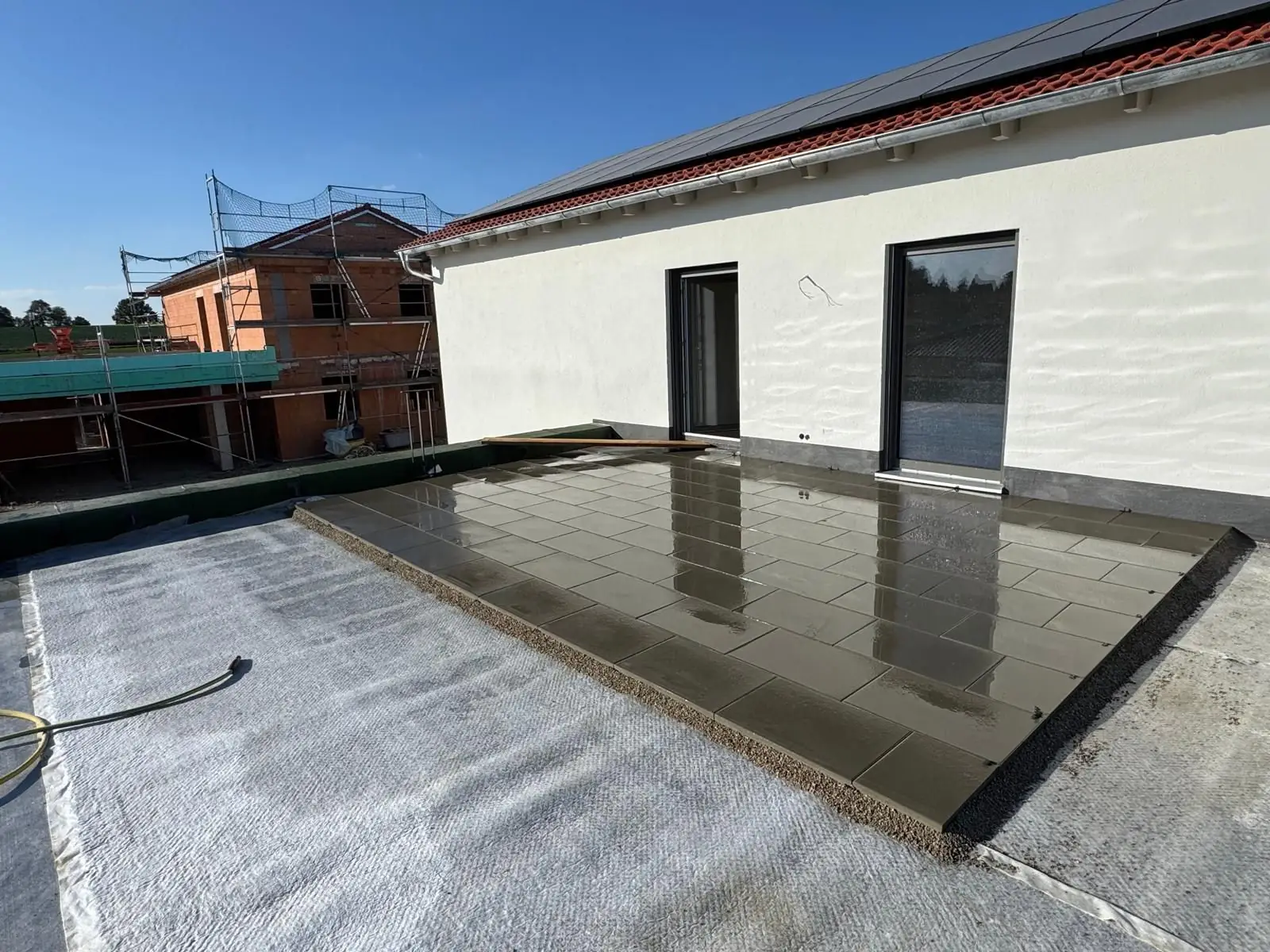 Terrassenplatten auf dem Dach neben der Vliesfläche
